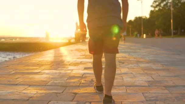 NIEDERES ENGEL: Männliche Touristen in kurzen Hosen und Turnschuhen spazieren die Promenade von Zadar entlang.