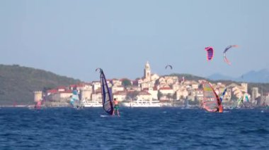 Güneşli bir günde Dalmaçya 'nın göbeğinde turistler rüzgar sörfü ve uçurtma..