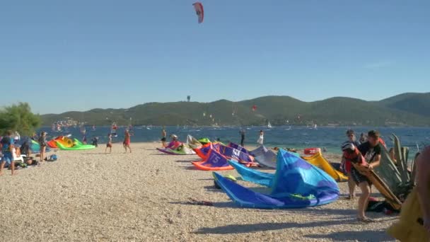 Αμέτρητοι τουρίστες συρρέουν στις ανεμοδαρμένες παραλίες του Peljesac να χαρταετό και windsurf. — Αρχείο Βίντεο