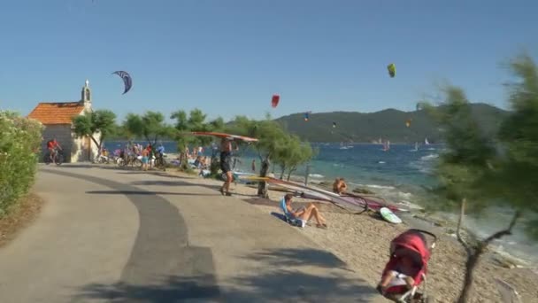 Camino de asfalto conduce a lo largo de una famosa playa de kitesurf en la costa de Croacia. — Vídeo de stock