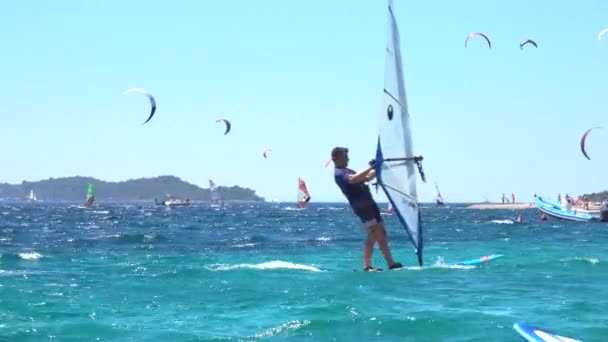 FECHAR-se: Windsurfers e kitesurfers passeio ondas no famoso destino de surf. — Vídeo de Stock