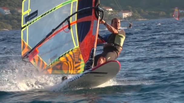 CLOSE UP: Atletisch mannelijk toeristisch kitesurfen tijdens zijn actieve zomervakantie — Stockvideo