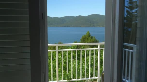 Weißes Geländer Balkon bietet einen Blick auf Strand bedeckt mit mediterranem Grün. — Stockvideo