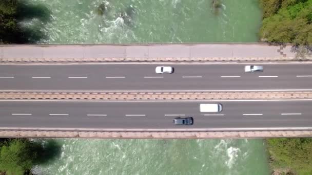 TOP DOWN: Cars cross a vibrant stream by driving down an urban motorway bridge. — Stock Video