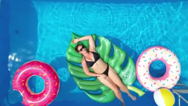トップダウン:女性でビキニリラックスで彼女の庭のプールで晴れた週末. — ストック動画