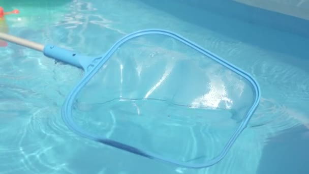 Близко: Неузнаваемый человек чистит стеклянный бассейн на заднем дворе. — стоковое видео