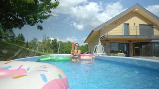 CLOSE UP: Joyful Caucasian female is enjoying the summertime in her home pool. — Stock Video