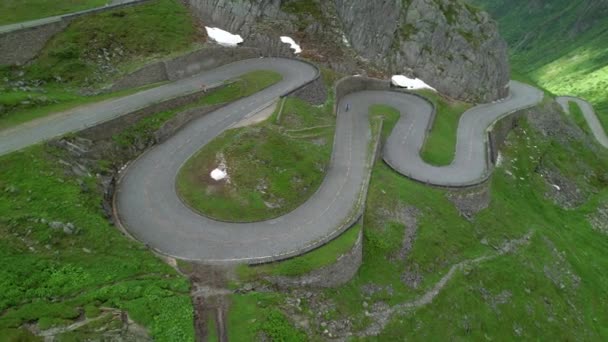 AERIAL: El ciclista cruza el paso de montaña de Gotthard en un día nublado de verano. — Vídeo de stock