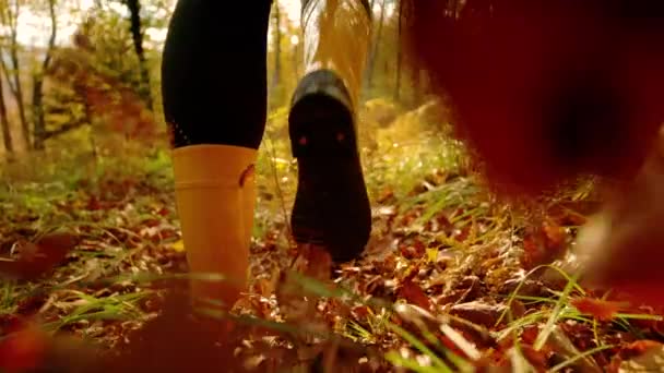 LOW ANGLE:森の中でイエローラバーブーツを履いた精力的な女性が走ります. — ストック動画