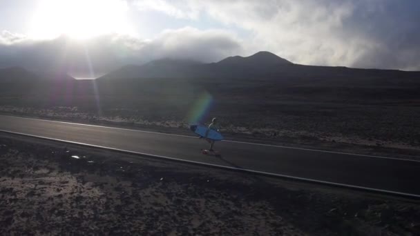 Longboard surfeur le long de la route vide — Video