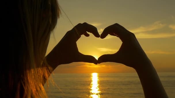 Sunset shining through heart shaped hands — Stock Video