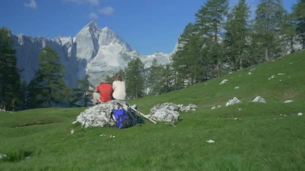 Туристы сидят на скале — стоковое видео