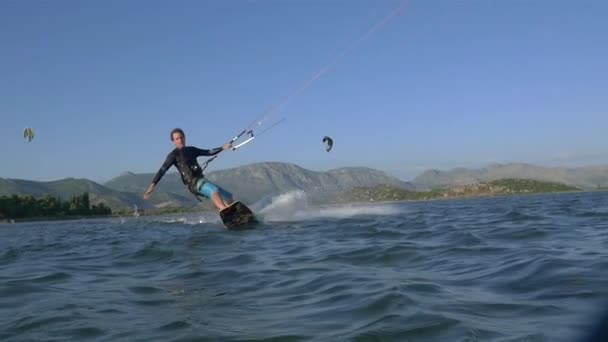 Kiteboarder montando a orillas — Vídeo de stock