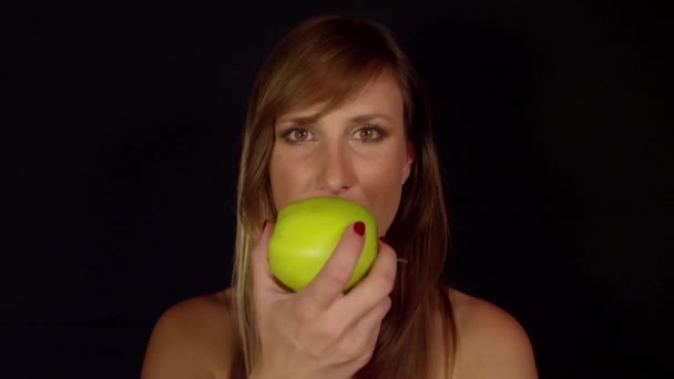 Kvinna tar en tugga av ett äpple — Stockvideo