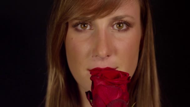Жінка пахне червоною трояндою і посміхається — стокове відео