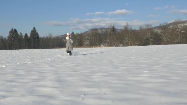 Mujer joven corriendo en la nieve — Vídeos de Stock