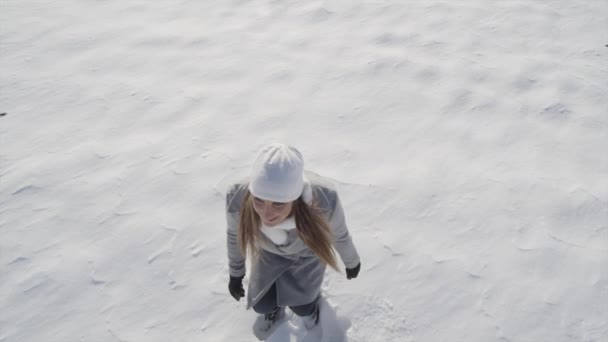 Jovem mulher fazendo anjos de neve — Vídeo de Stock