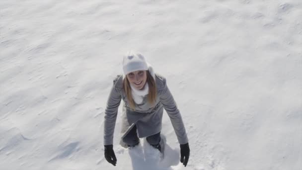 Woman making angels in fresh snow — Stock Video