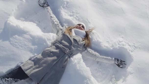 快乐的女人做雪天使 — 图库视频影像