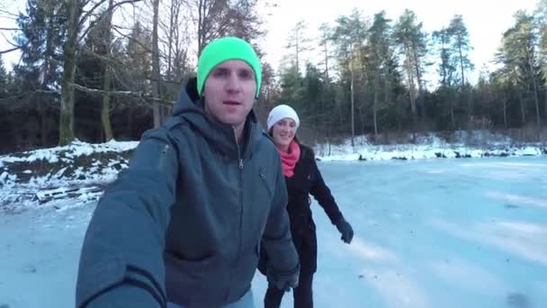 Pareja patinaje sobre hielo en el lago congelado — Vídeo de stock