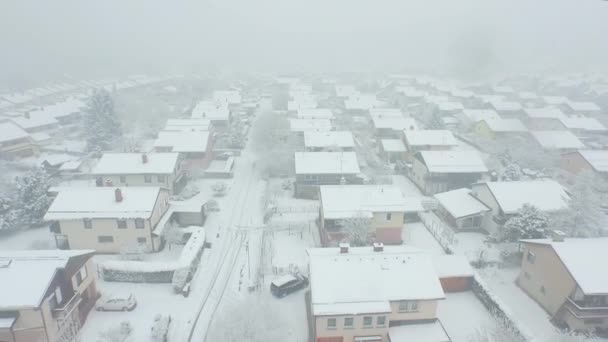 Voler au-dessus des maisons de banlieue dans la neige lourde — Video