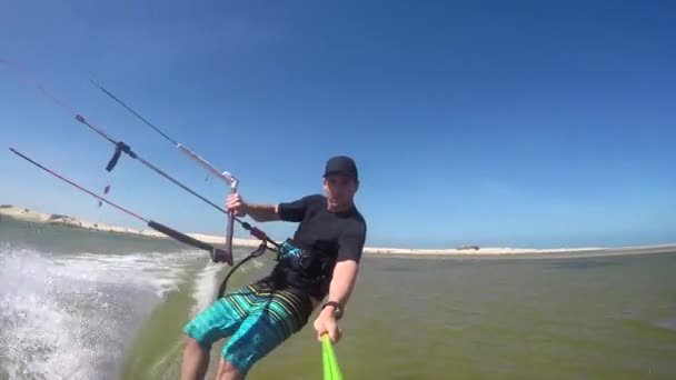 Vrolijke kiteboarder rijden op vlakke water — Stockvideo