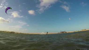 Gelişmiş kiteboarder güneşin üzerinde yüksek atlama