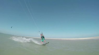 Atlama ve shaka kameraya gösteren Kiteboarder