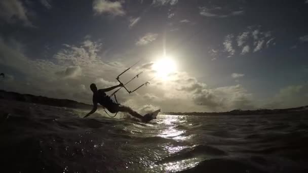 Vrouwelijke kiteboarder paardrijden en spatten — Stockvideo