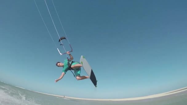 Kiteboarder sautant et montrant signe shaka — Video