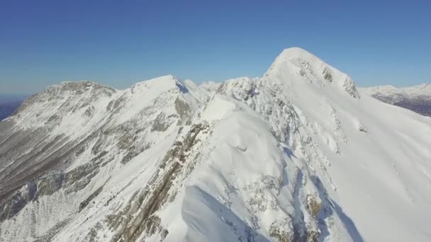 Volando sobre la cresta de la montaña en invierno nevado — Vídeo de stock