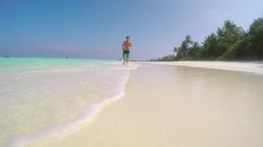 Adam sığ suda sahilde koşu