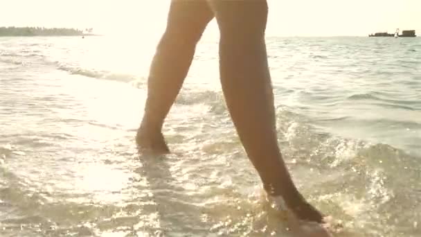 Walking on sandy beach splashing water — Stock Video