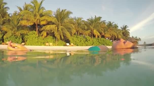 Mujer joven flotando en la superficie del agua — Vídeo de stock