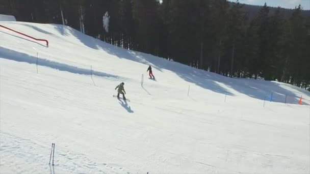 Snowboarder springen de kicker in snowboardpark — Stockvideo