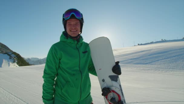 Corsa sorridente snowboarder nella stazione sciistica — Video Stock