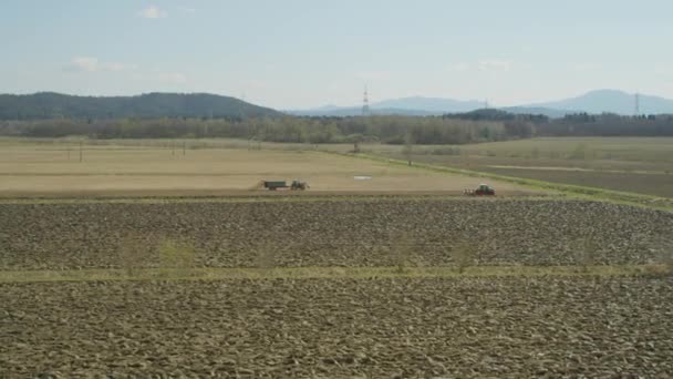 Traktoren arbeiten im zeitigen Frühjahr auf einem Feld — Stockvideo