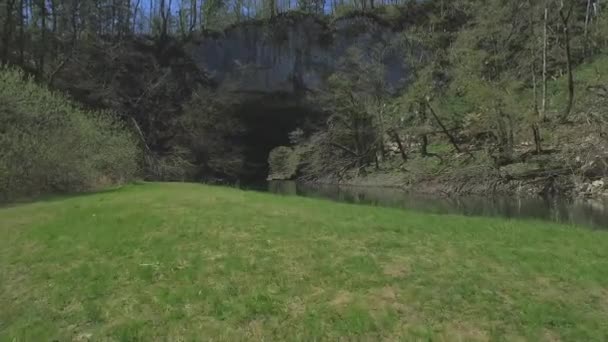 AERIAL: Volando bajo un puente rocoso natural sobre el río — Vídeos de Stock
