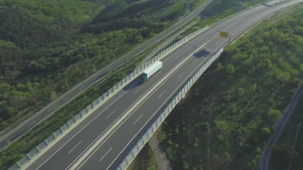 AÉRIAL : Camion porte-conteneurs circulant le long de l'autoroute vide 