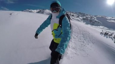 Selfie: kışın güneşli bir dağda toz sürme Snowboarder