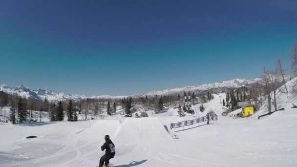 SLOW MOTION: Young snowboarder jumping the kicker in snow park — Stock Video