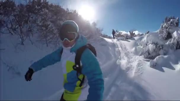 Сноубордисты, катающиеся на свежем снегу на солнечной горе — стоковое видео