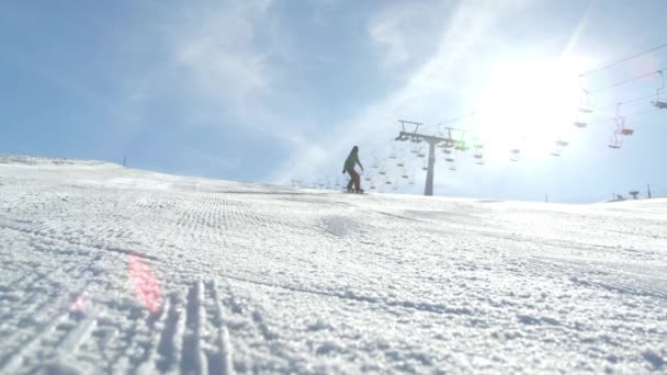 Movimiento lento: Carrera snowboarder tallado por la pista de esquí helado — Vídeo de stock