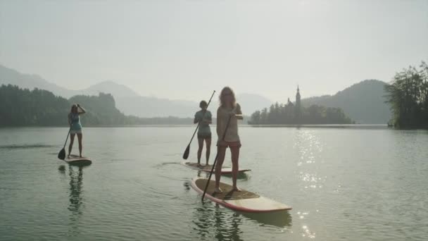 Zeitlupe: Surfermädchen beim Sonnenaufgang auf dem schönen See — Stockvideo