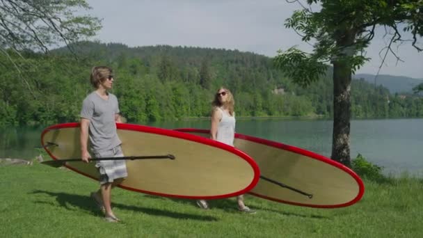 Zeitlupe: Freund und Freundin beim Stand Up Paddling mit Surfbrettern — Stockvideo