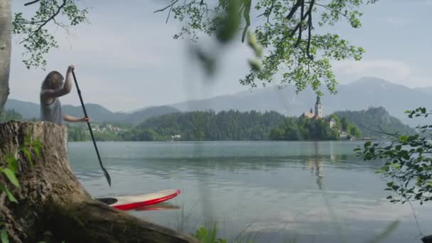 SLOW MOTION: Young couple standup paddling on SUP boards on a date — Stock Video