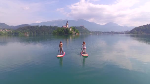 AÉRIAL : Jeune couple et un ami se rencontrent sur les conseils SUP sur le lac saigné — Video