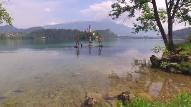 Letecká anténa: létání nad přáteli SUP na ostrov jezera Krvat — Stock video