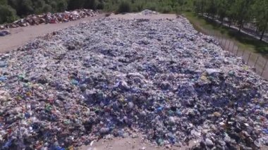 Anten: Çöplükteki büyük boş şişeler, poşetler ve diğer plastik yığınları