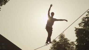 Yavaş Hareket: Altın gün batımında gevşek likte yürüyen genç adam